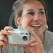 Junge Frau mit Digitalkamera lacht